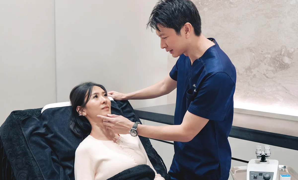 Dr Gerard Ee assessing a patient's lower eyelids before recommending an eye bag treatment