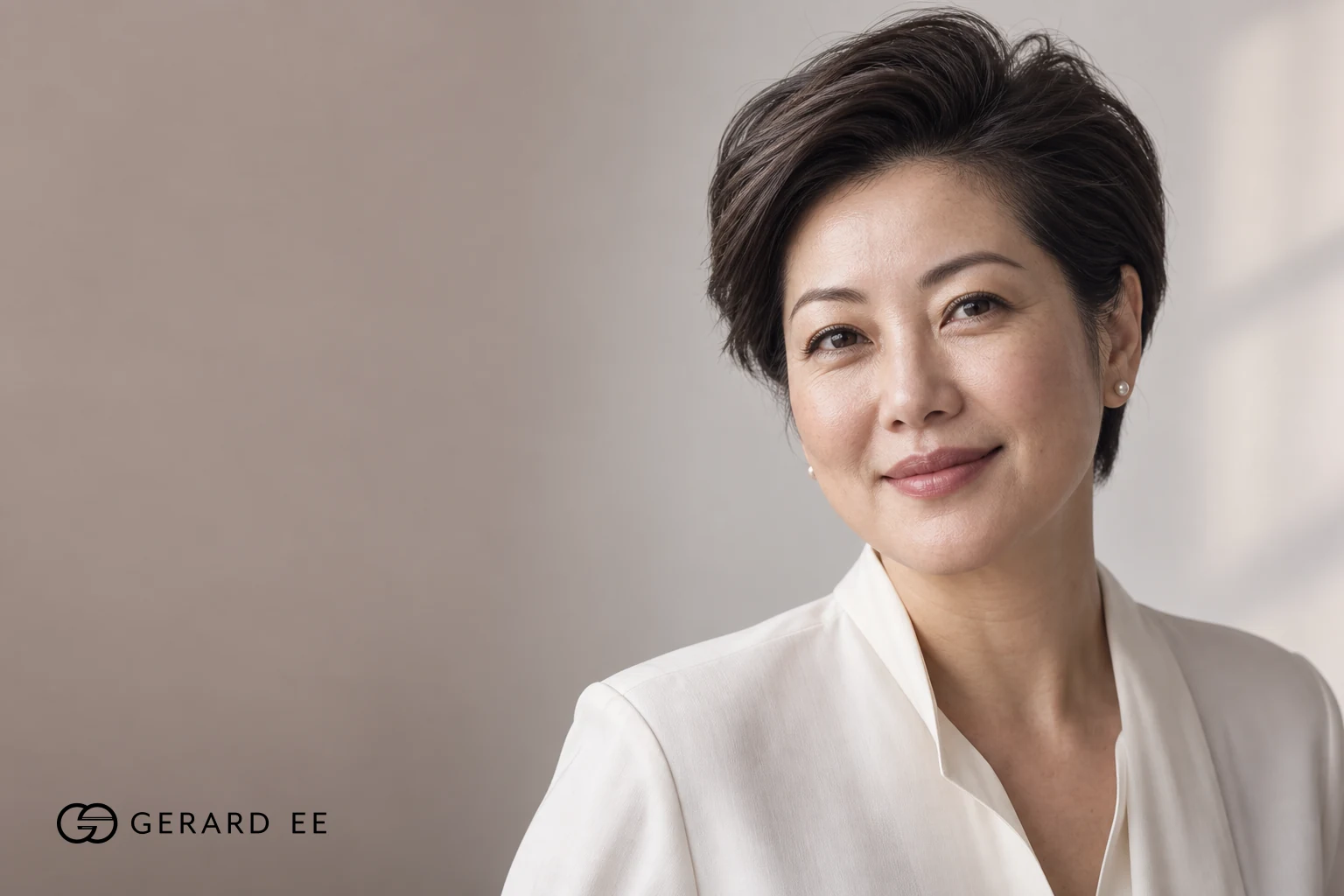Woman with short dark hair in a white blouse, photographed in soft natural light