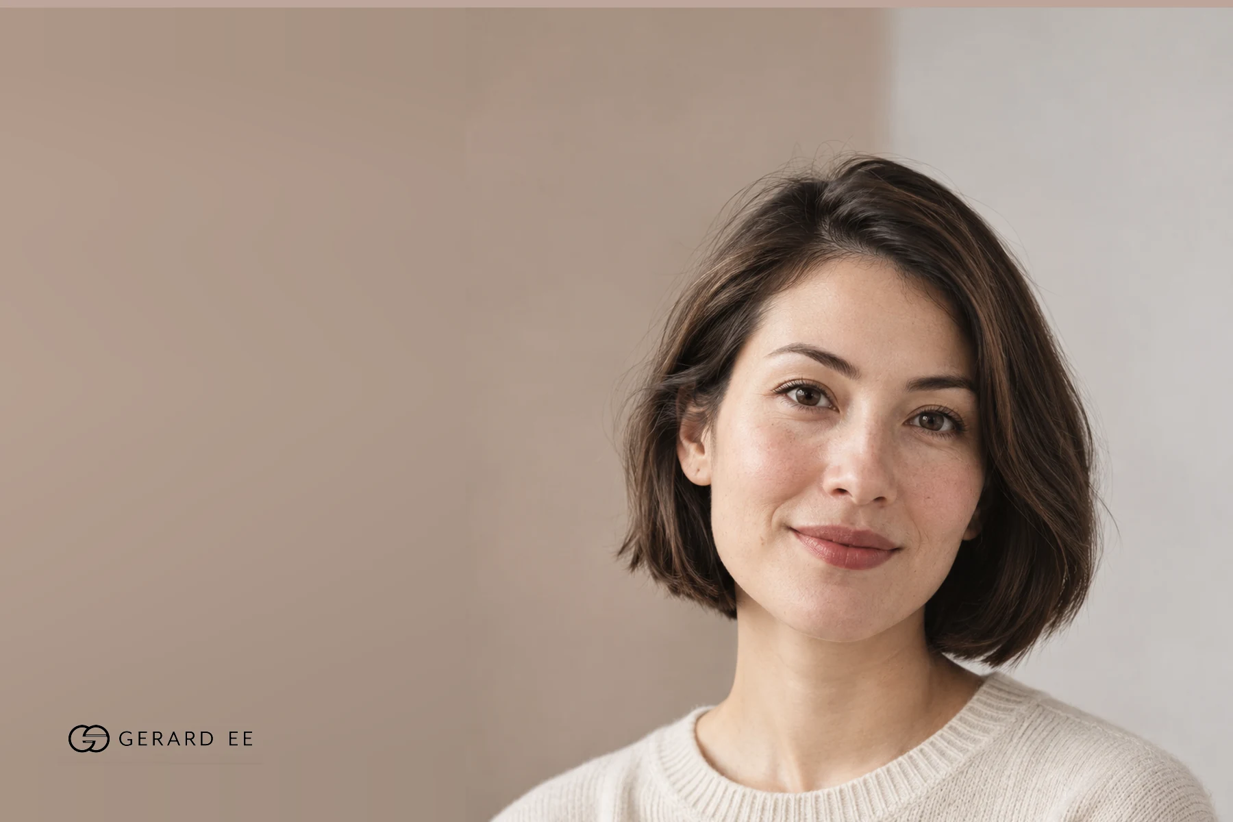 Woman with a dark bob in a cream sweater, photographed in soft natural light