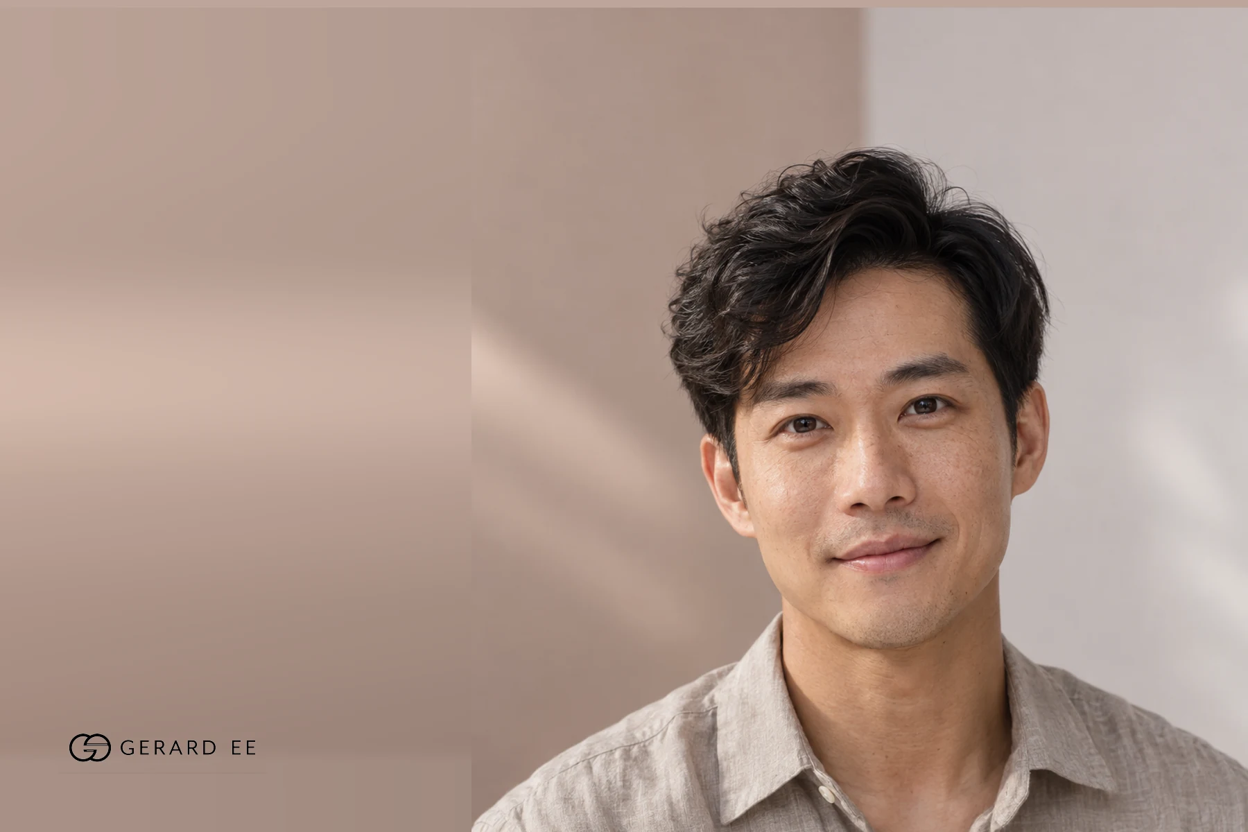 Man with wavy dark hair in a beige linen shirt, photographed in soft natural light